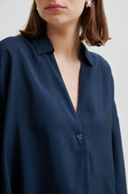 Navy blue shirt worn by a person on a white background