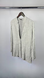 Green and white striped shirt on a hanger against a plain background