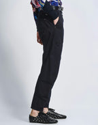 Person wearing black pants with cut-out design on a white background