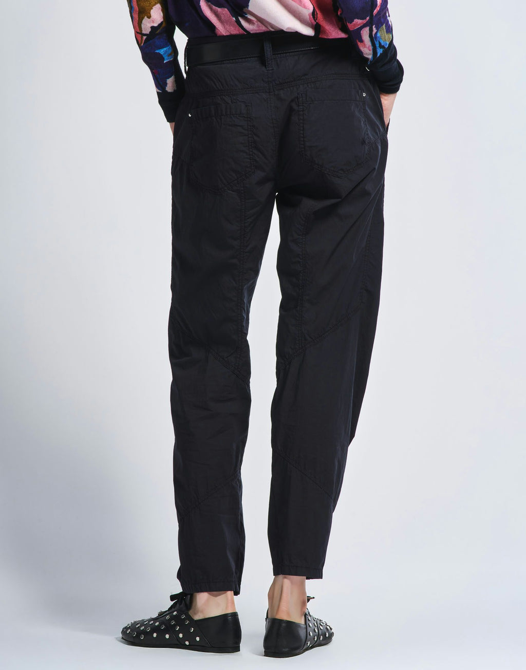 Person wearing black pants on a white background