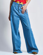 Person wearing blue wide-leg jeans on a white background