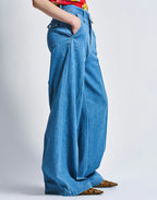 Person wearing blue wide-leg jeans on a plain background