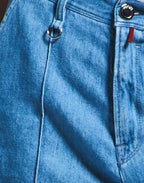 Close-up of blue jeans with a brand logo on the pocket.
