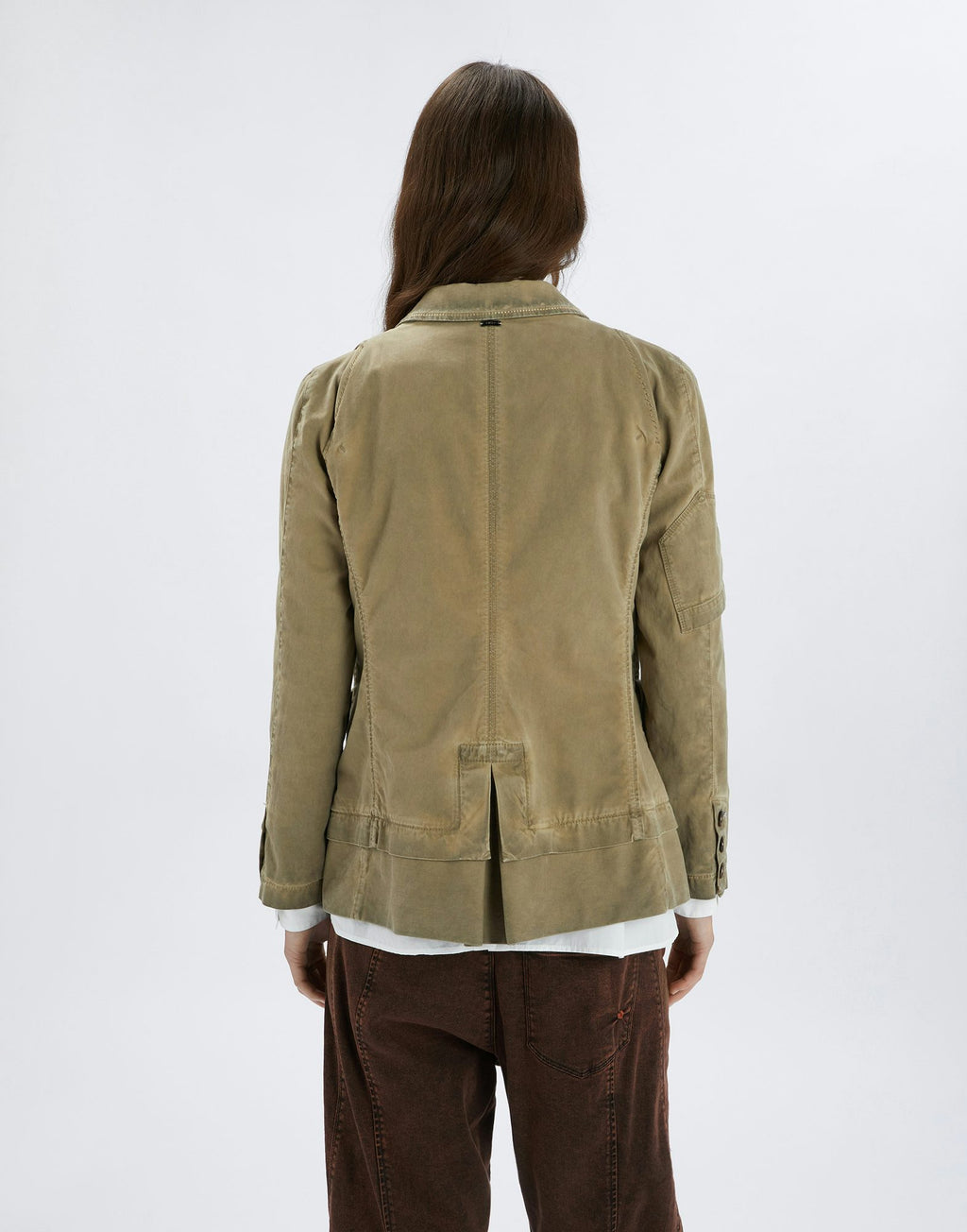 Person wearing a beige jacket on a white background