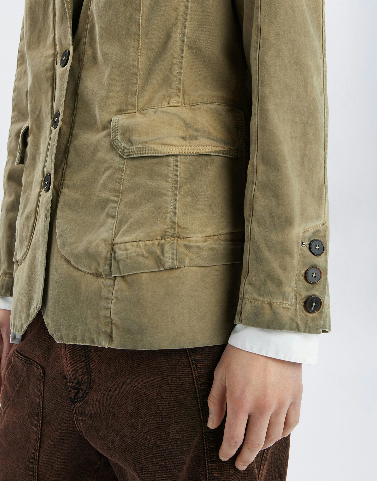 Close-up of a green jacket with button details on a white background