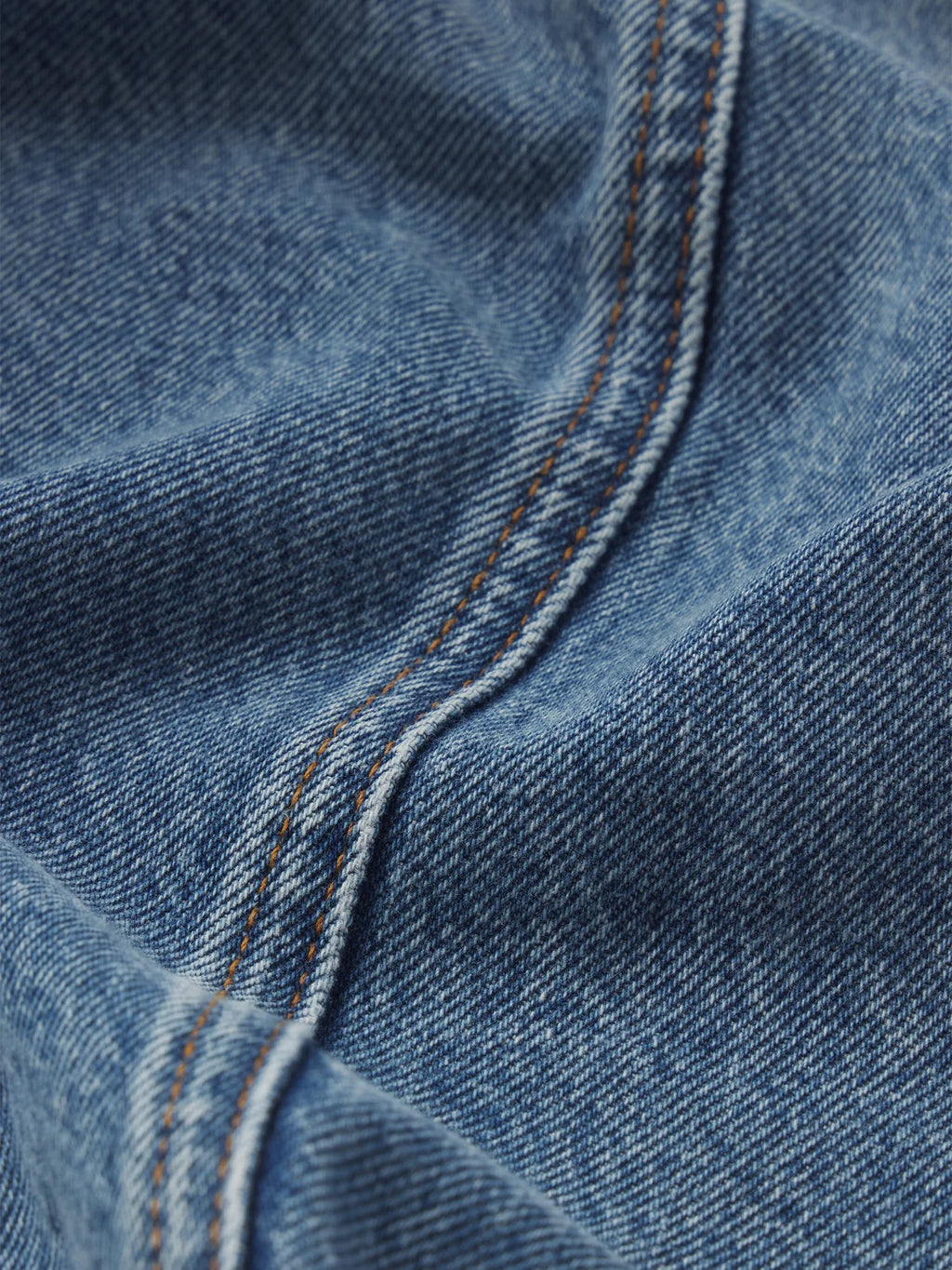 Close-up of blue denim fabric with stitching detail