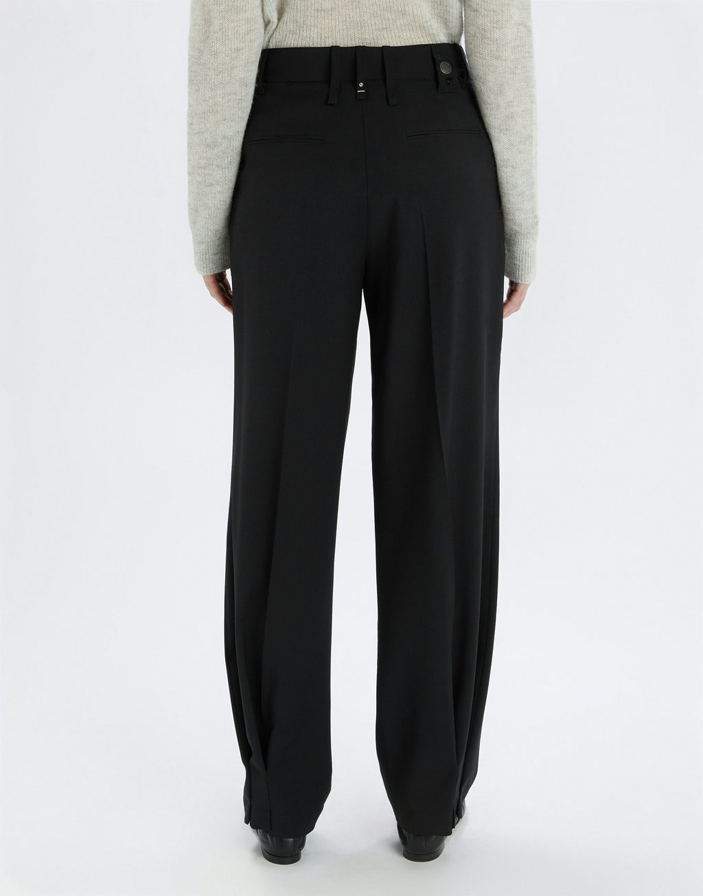 Black pants worn by a person on a white background