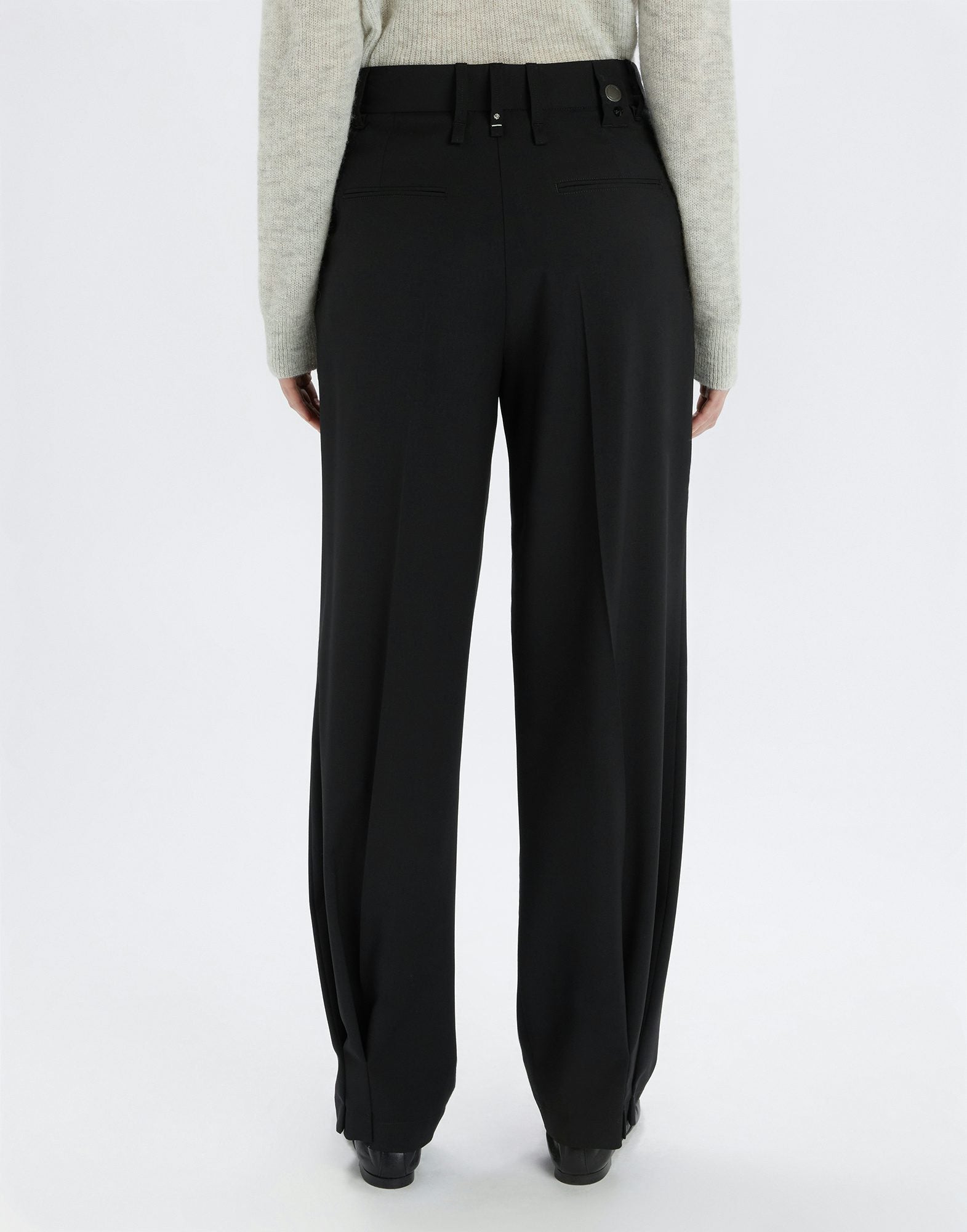 Black pants worn by a person on a white background