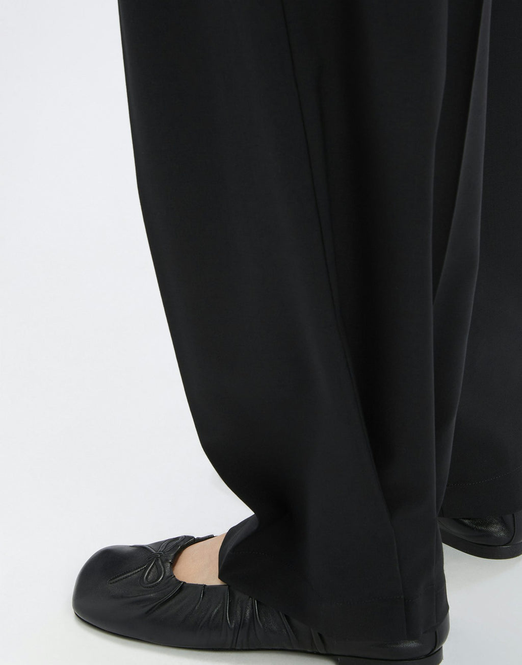 Black pants worn by a person on a white background
