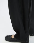 Black pants worn by a person on a white background
