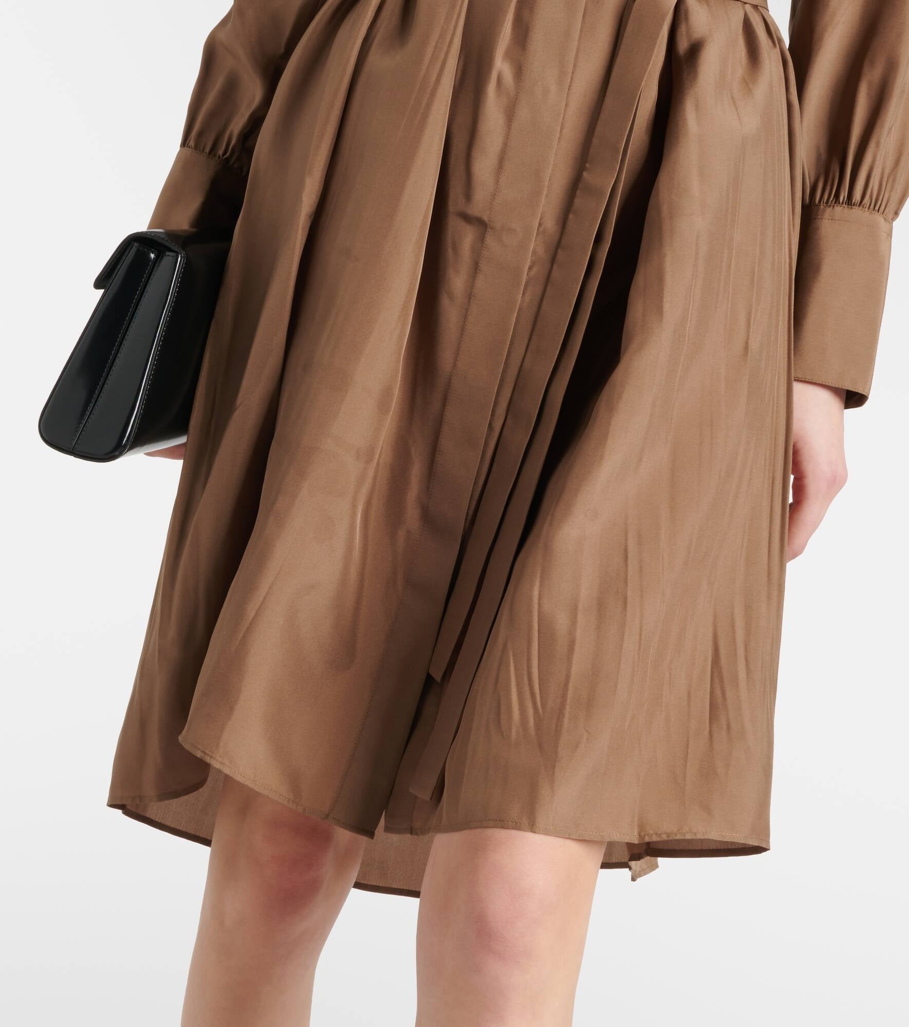 Brown dress with a black handbag on a white background