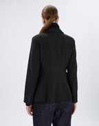 Person wearing a black jacket on a white background