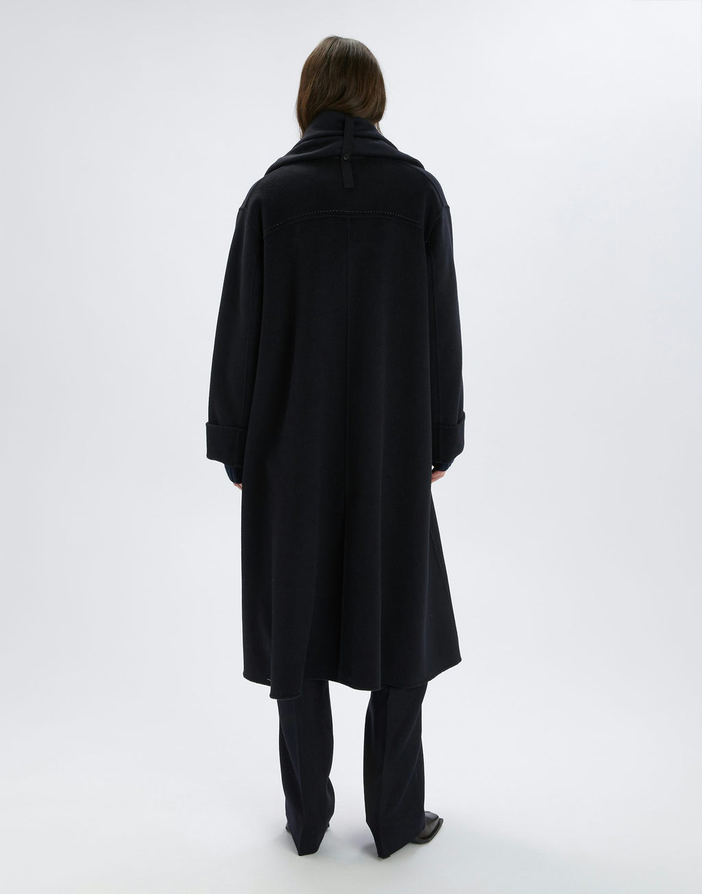 Person wearing a black coat on a white background
