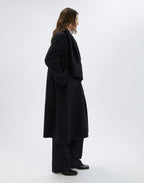 Person wearing a black coat on a white background