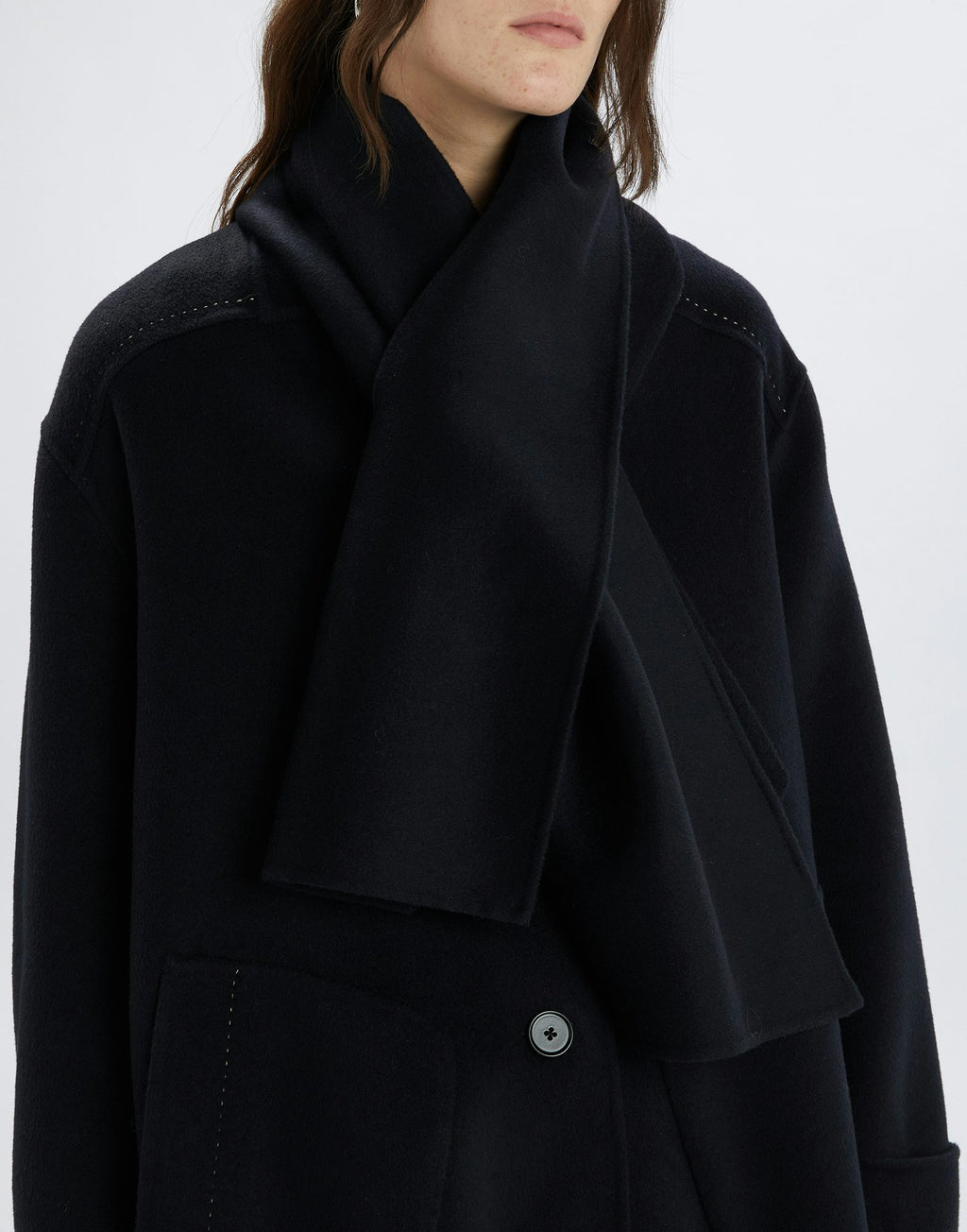Black coat worn by a person on a white background