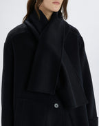 Black coat worn by a person on a white background
