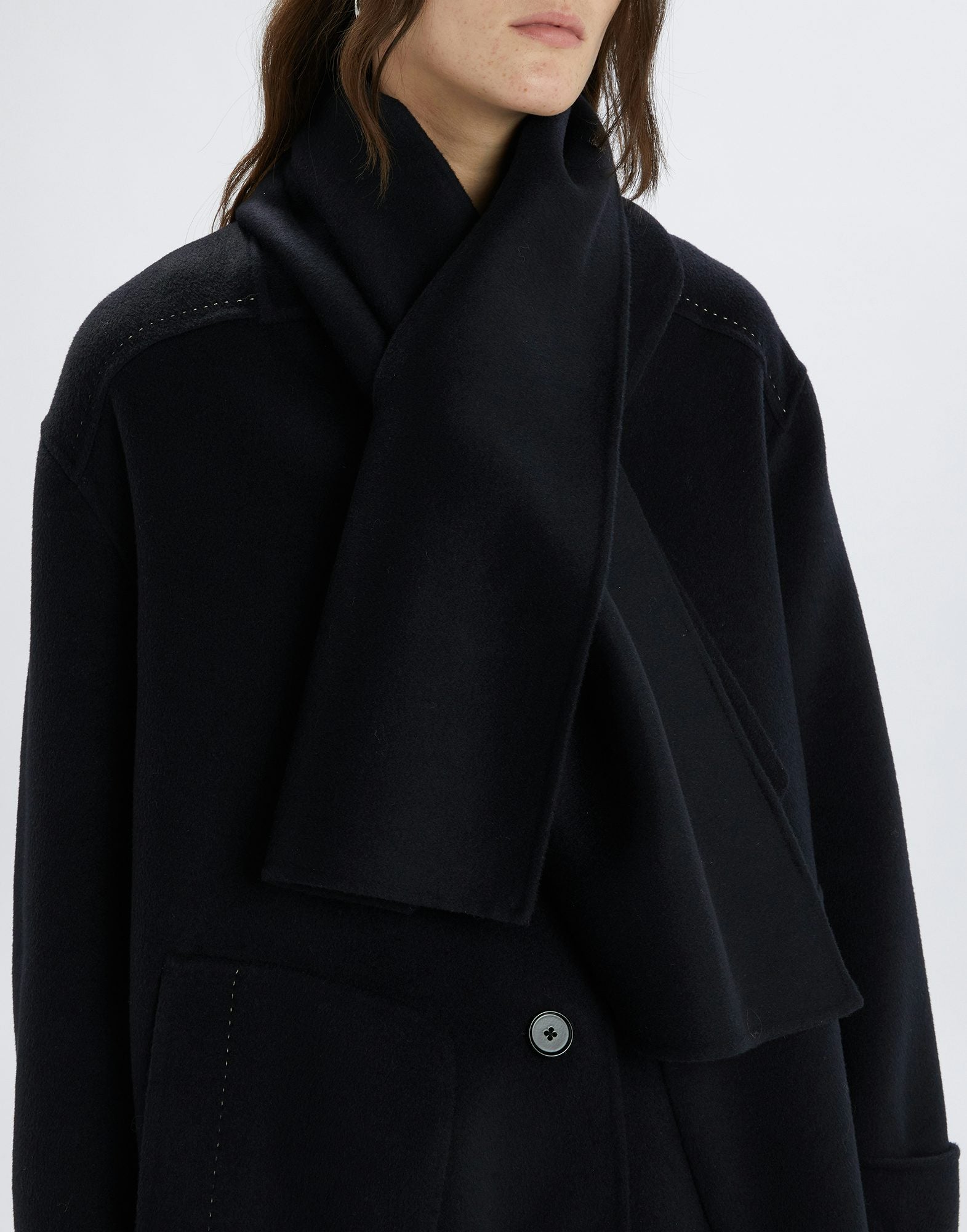 Black coat worn by a person on a white background