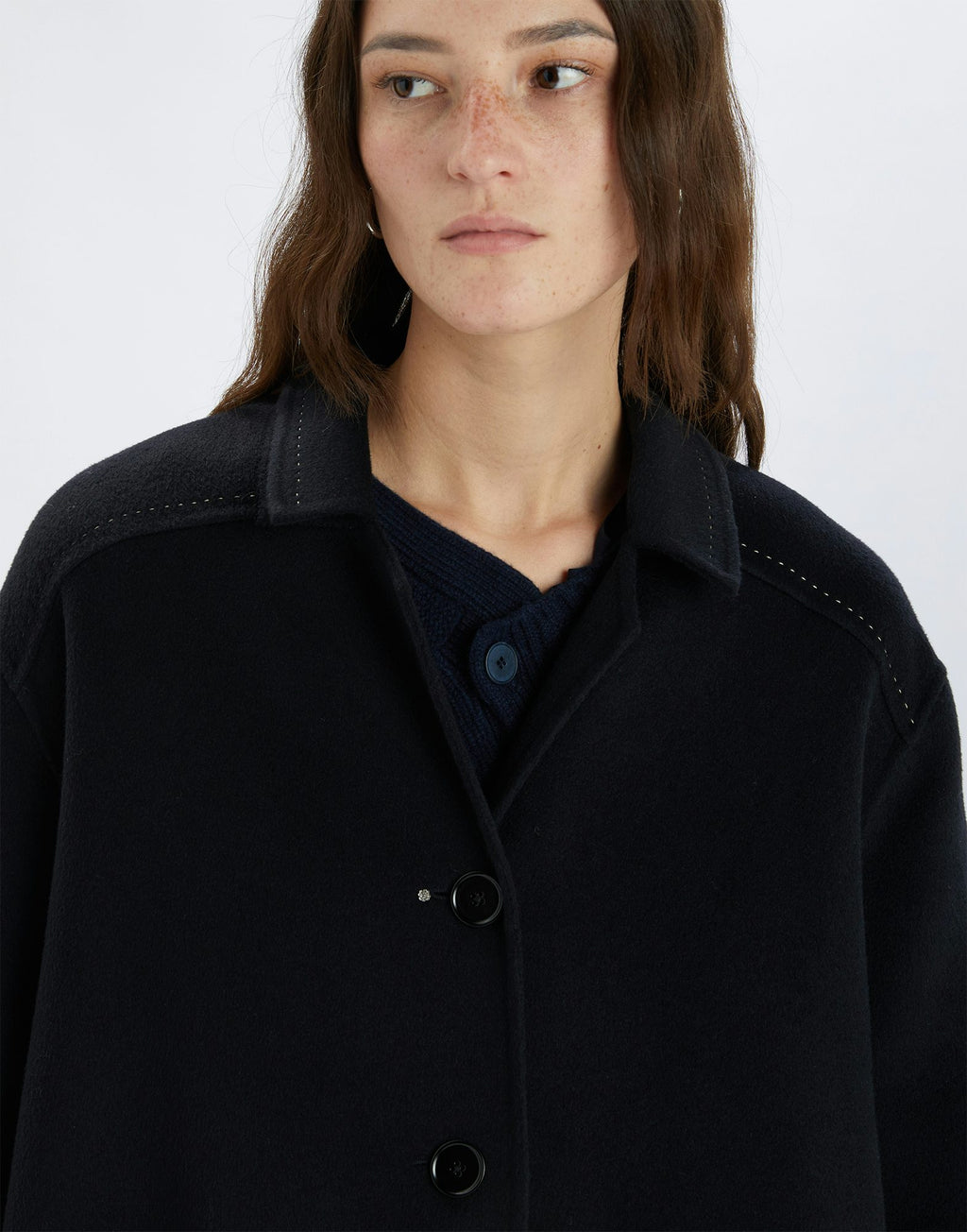 Person wearing a dark coat on a white background