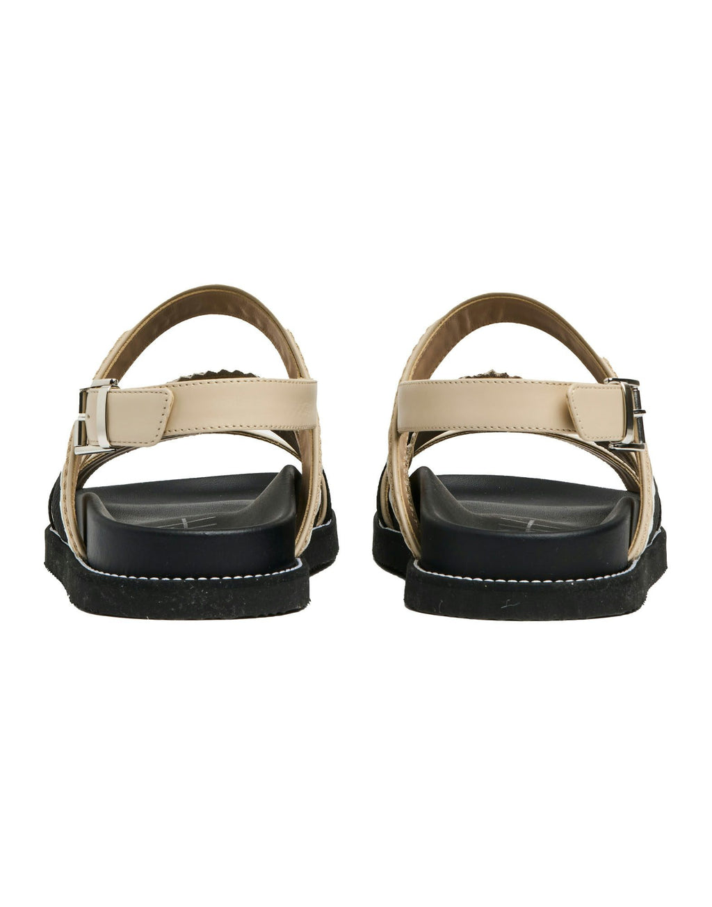 Pair of sandals with beige straps and black soles on a white background