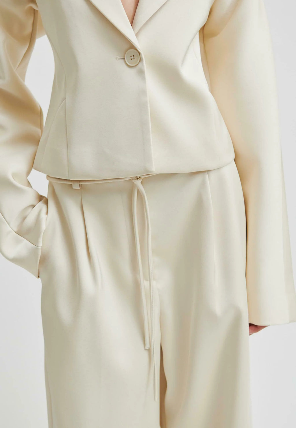 Beige suit with a jacket and pants on a light background