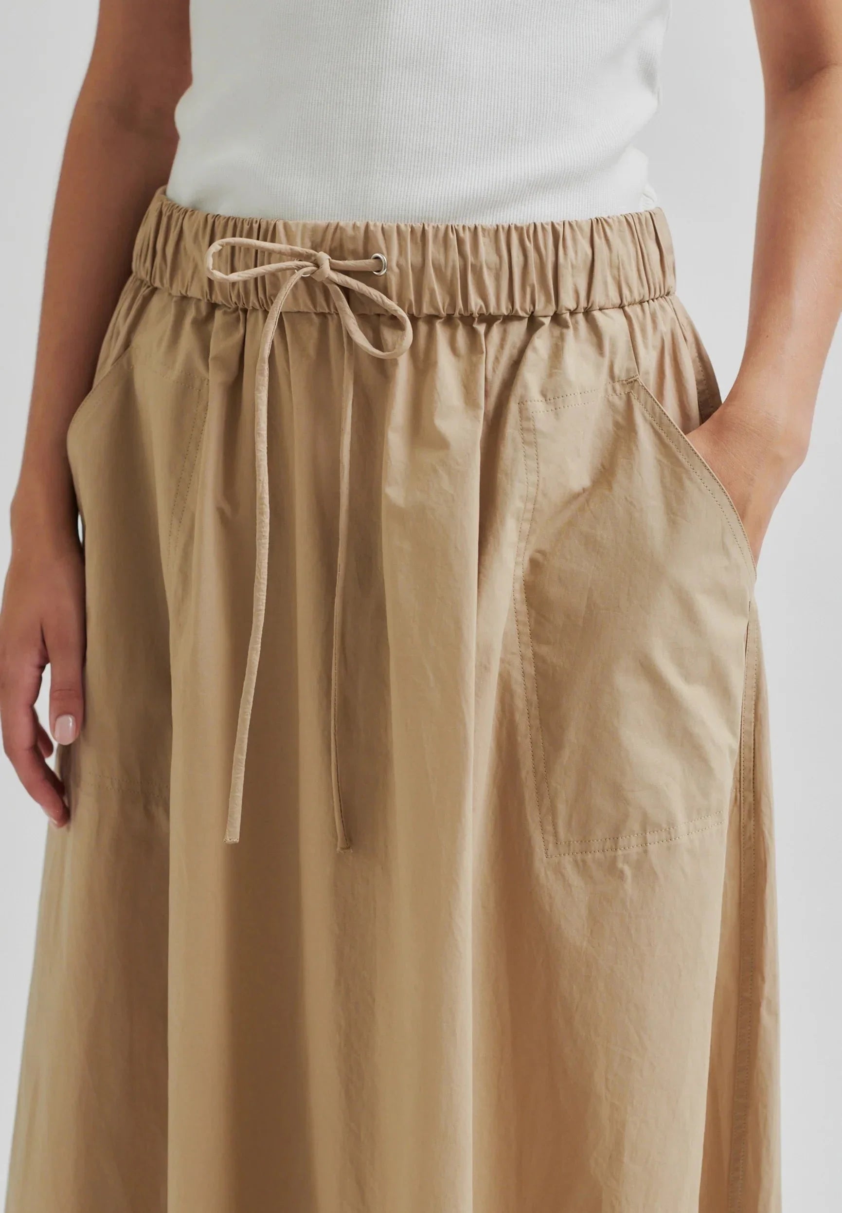 Beige wide-leg pants with drawstring waist on a white background