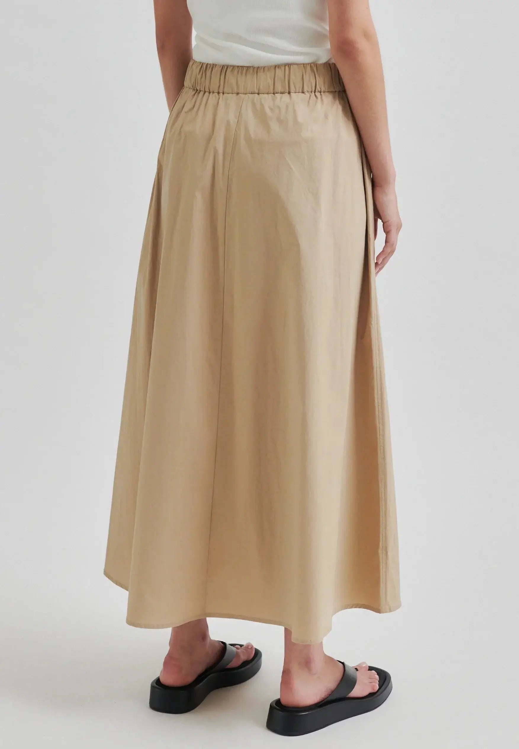 Person wearing a beige skirt on a white background