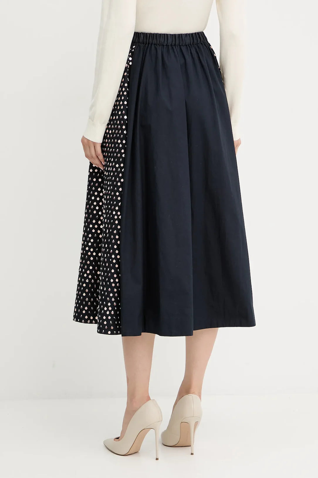 Navy skirt with polka dot side panel worn by a person on a white background