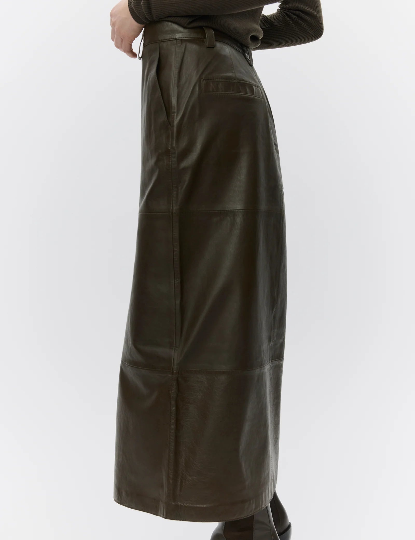 Brown leather skirt worn by a person on a white background