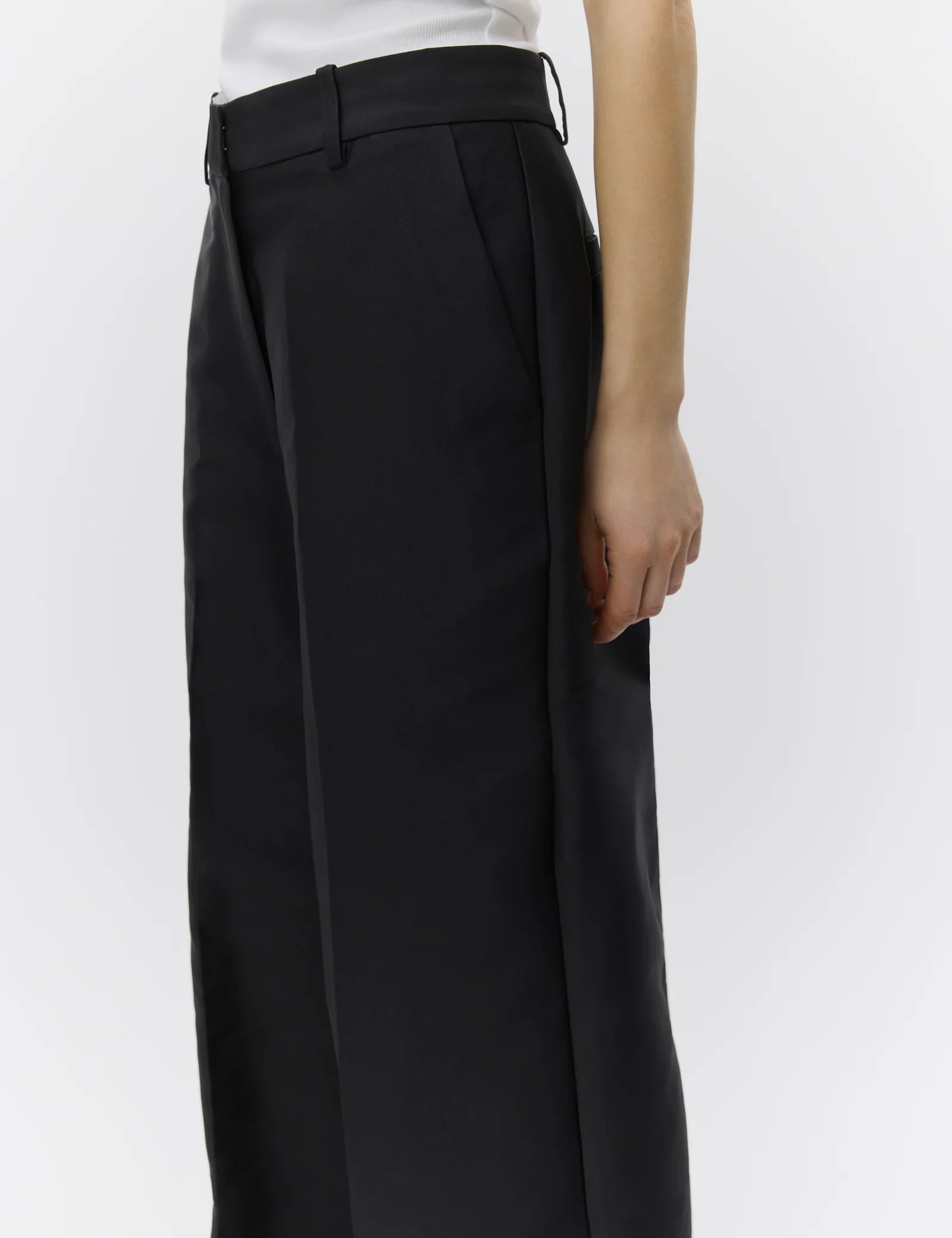 Black wide-leg pants worn by a person on a white background