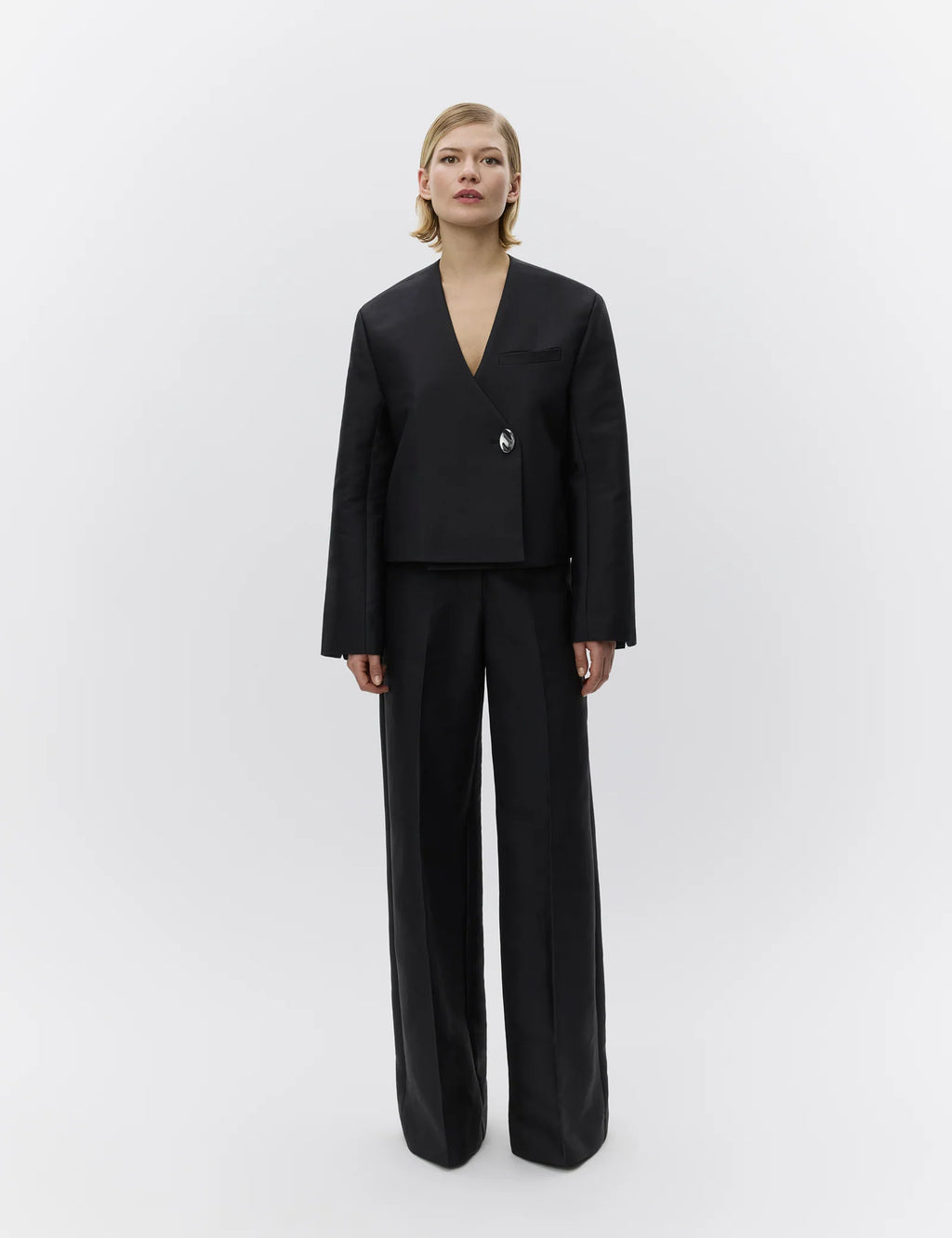 Woman wearing a black suit on a white background
