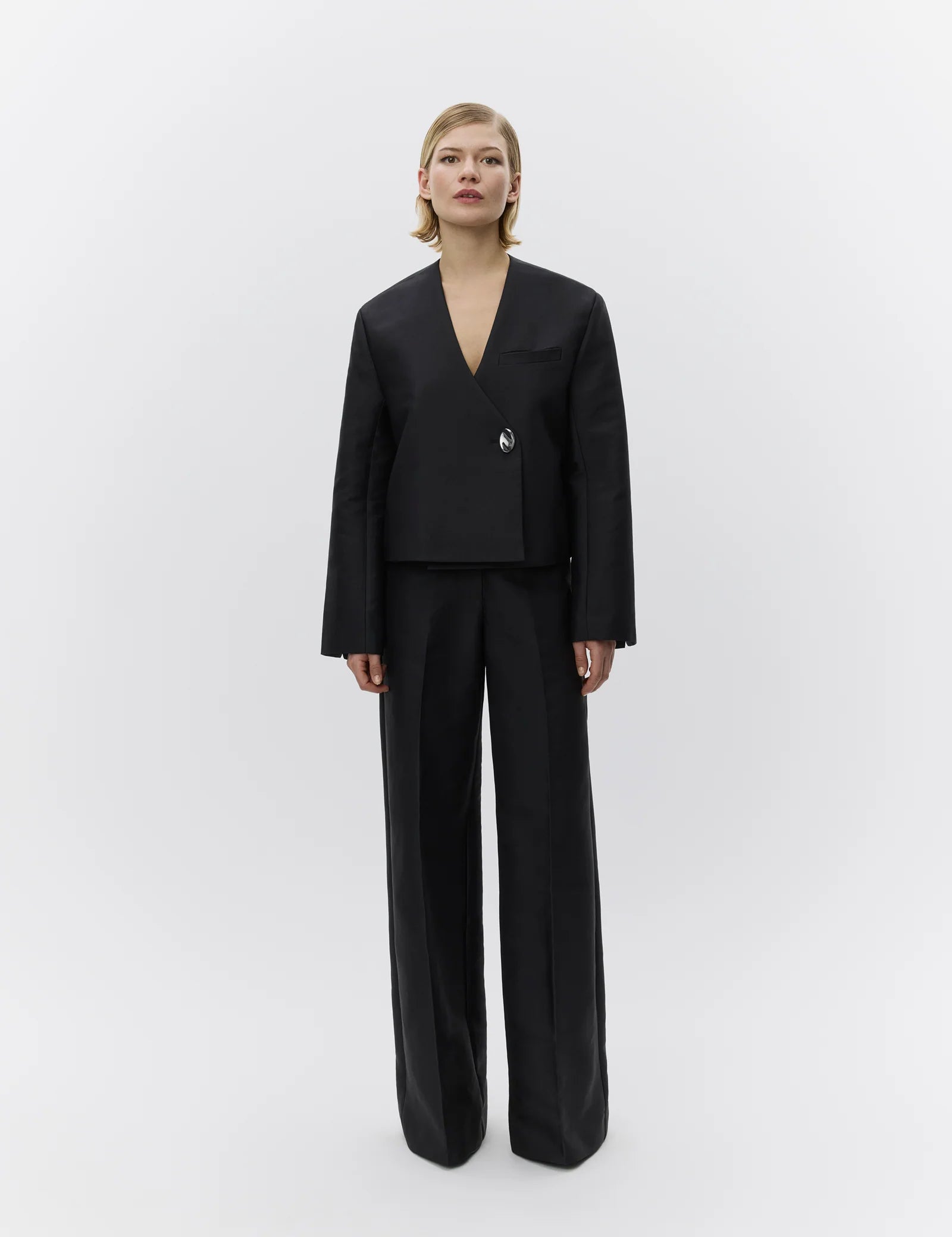 Woman wearing a black suit on a white background