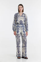 A model wearing straight-leg, cotton trousers with side pockets and a floral pattern.