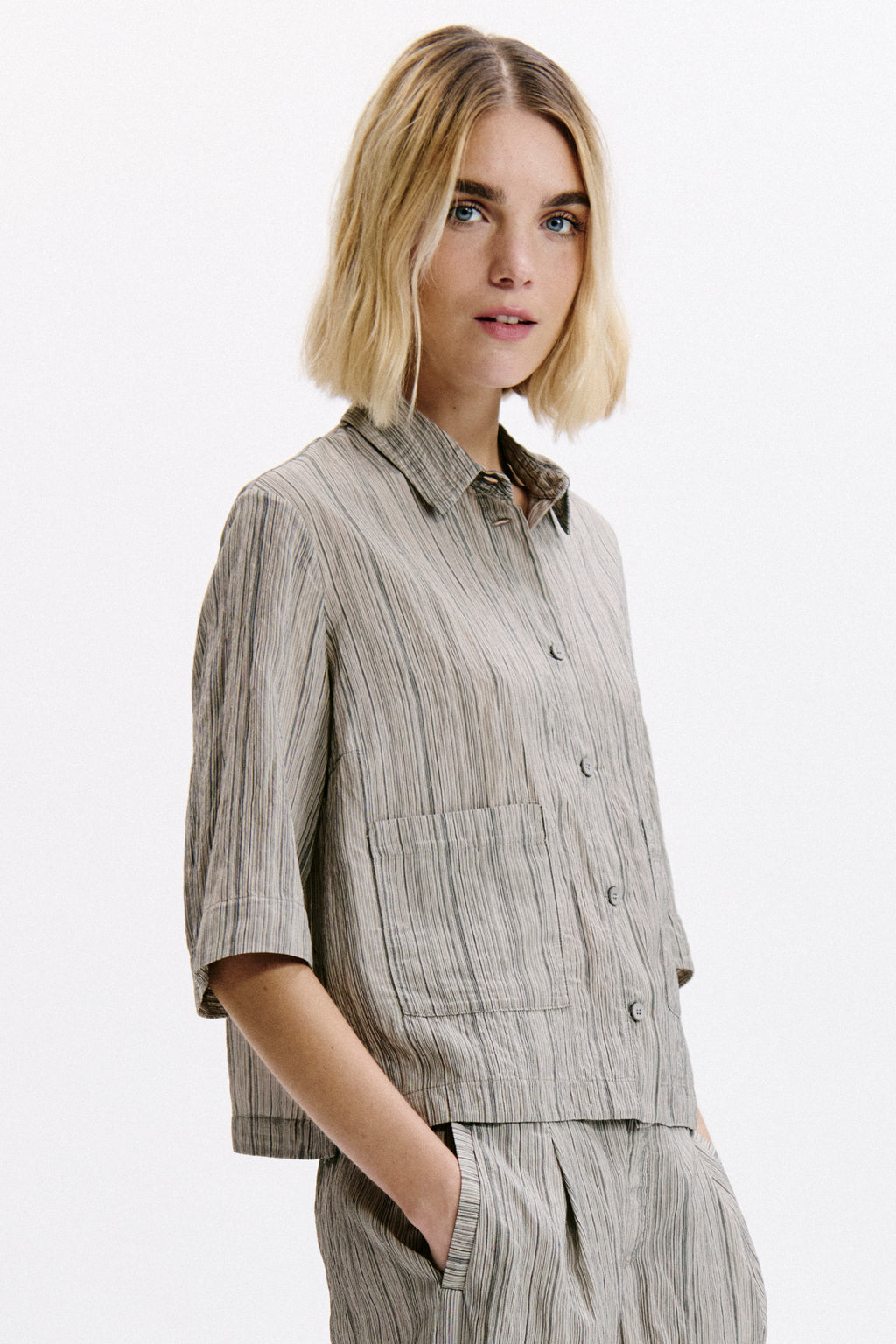 Woman wearing a striped shirt and pants on a white background