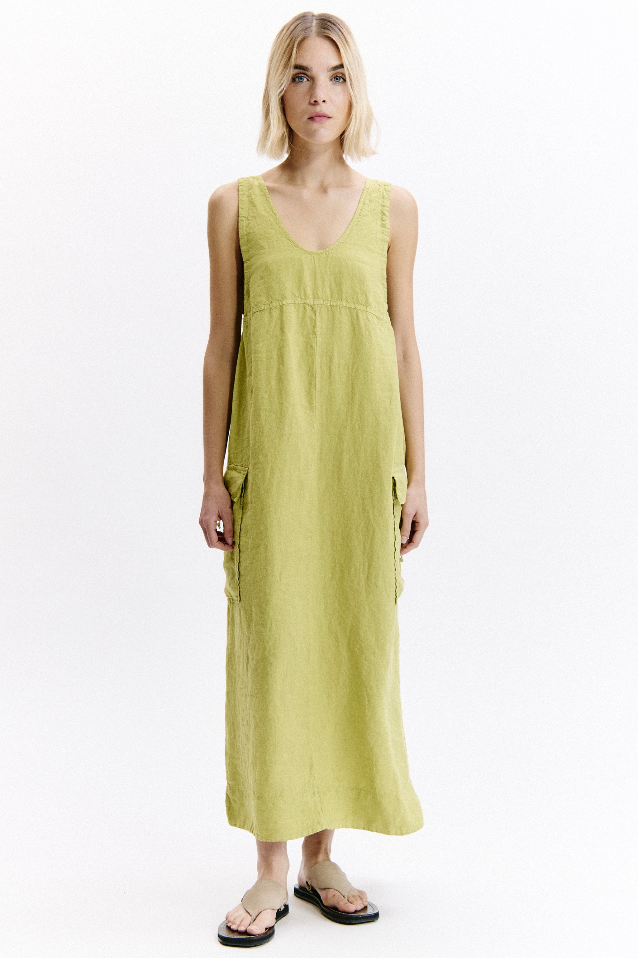 Woman wearing a yellow sleeveless dress on a white background