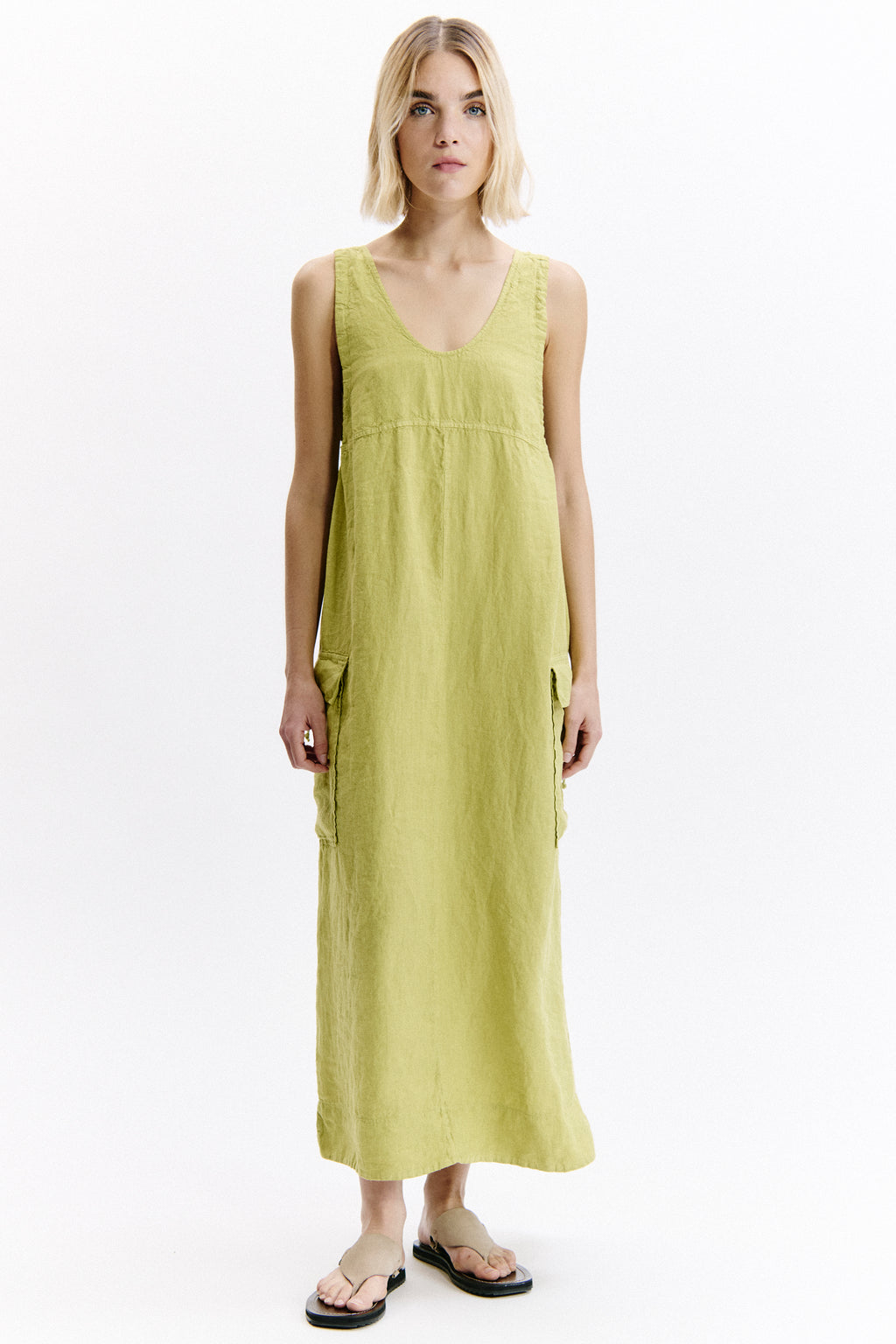 Woman wearing a yellow sleeveless dress on a white background