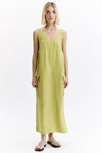 Woman wearing a yellow sleeveless dress on a white background