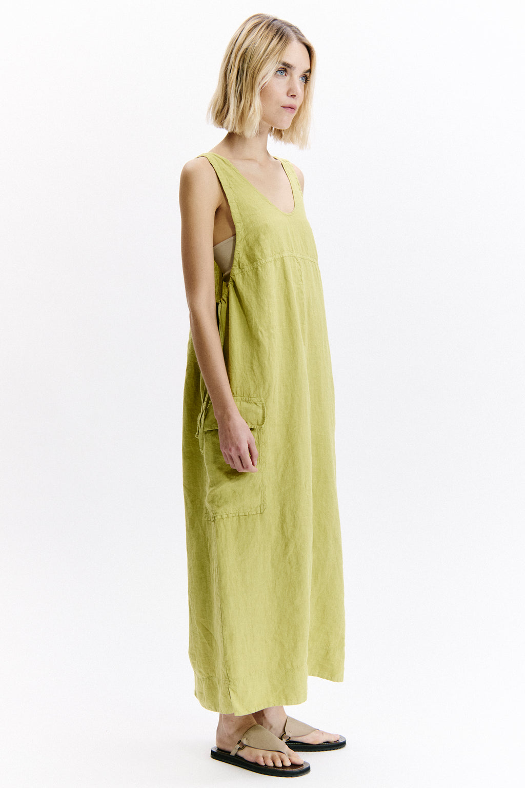 Woman wearing a long light green dress on a white background