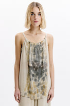 Woman wearing a sleeveless top with a geometric pattern on a white background