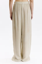 Beige wide-leg pants worn by a person on a white background