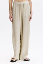 Beige wide-leg pants worn by a person on a white background