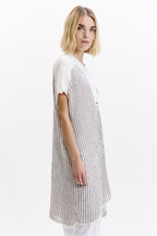 Woman wearing a white and black striped dress on a white background