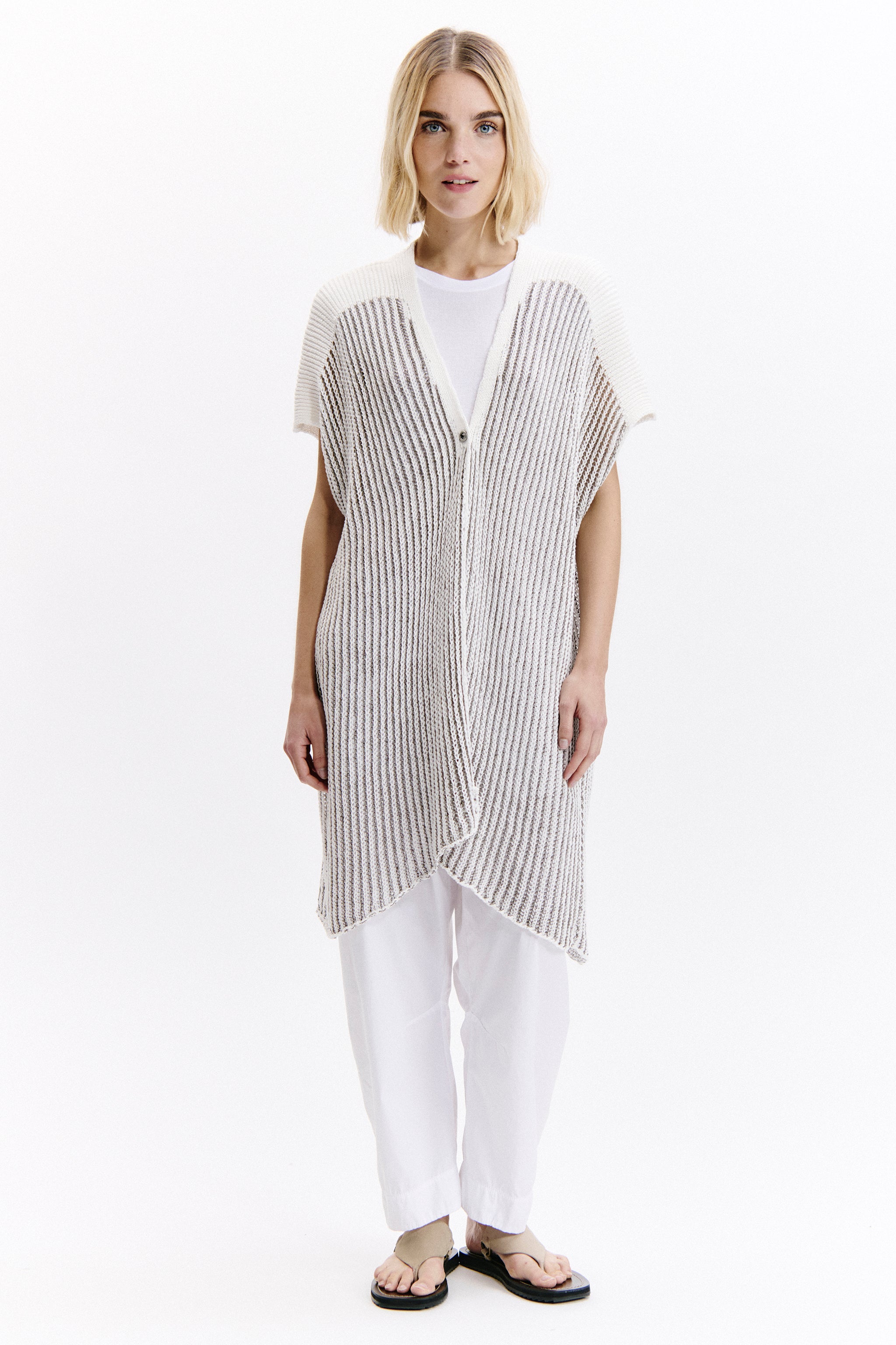 Woman wearing a black and white striped vest over a white shirt on a white background