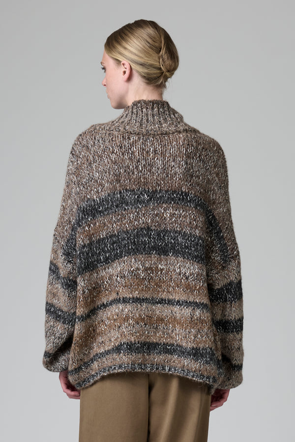 Woman wearing a striped sweater against a plain background