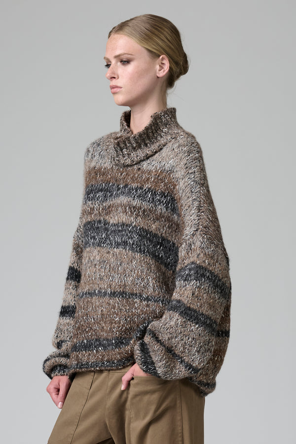 Woman wearing a striped sweater against a plain background