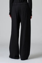 Black wide-leg pants worn by a person on a white background