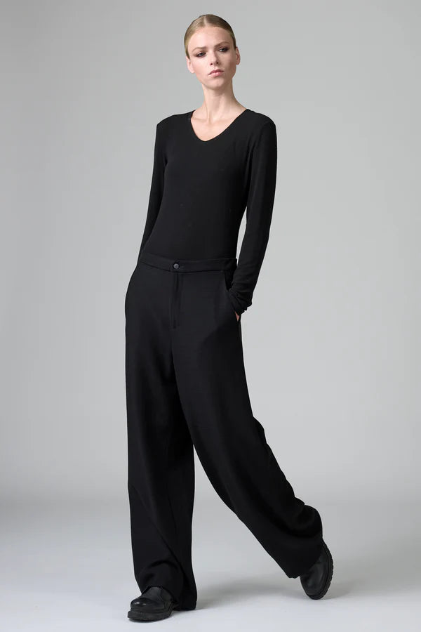 Person wearing a black outfit on a gray background