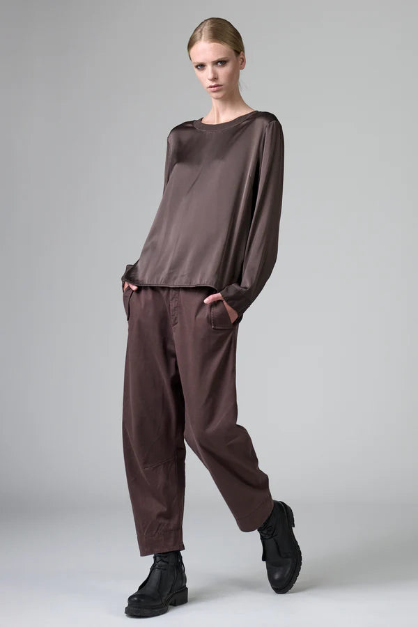Model wearing a brown outfit with a plain background