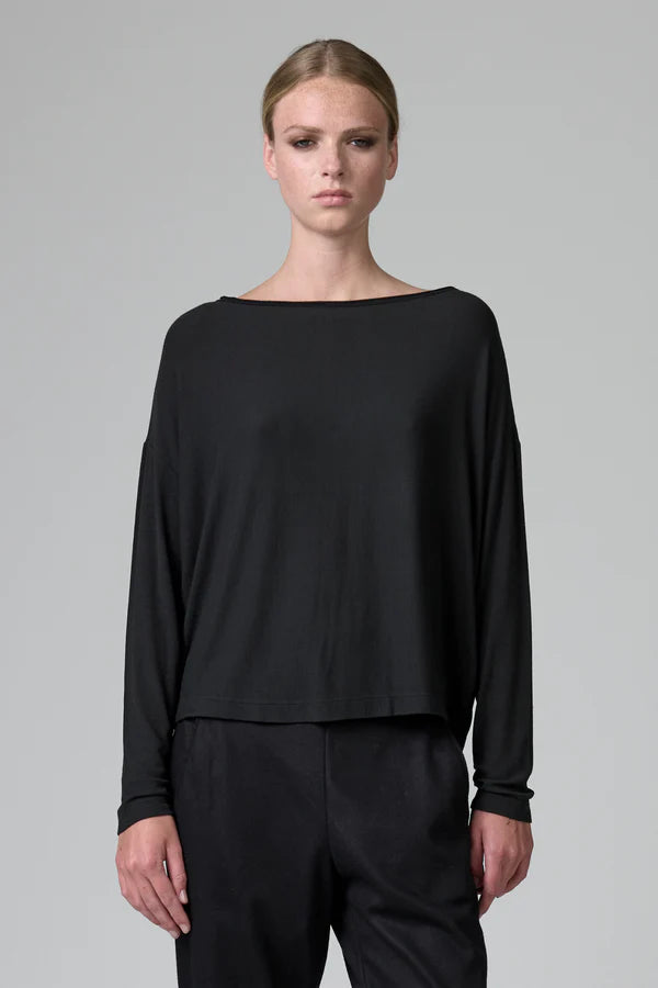 Model wearing a black long-sleeve top and pants on a gray background