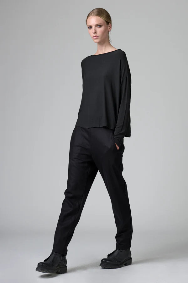 Person wearing a black outfit on a gray background