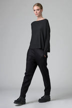 Person wearing a black outfit on a gray background